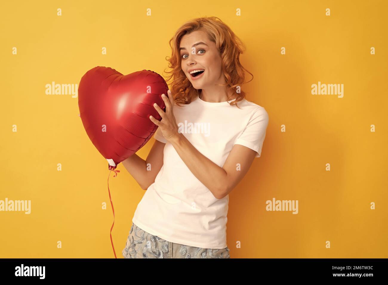 Erstaunt glücklich Rotschopf Mädchen mit Liebe Herz Ballon. Nächstenliebe und Spende Stockfoto