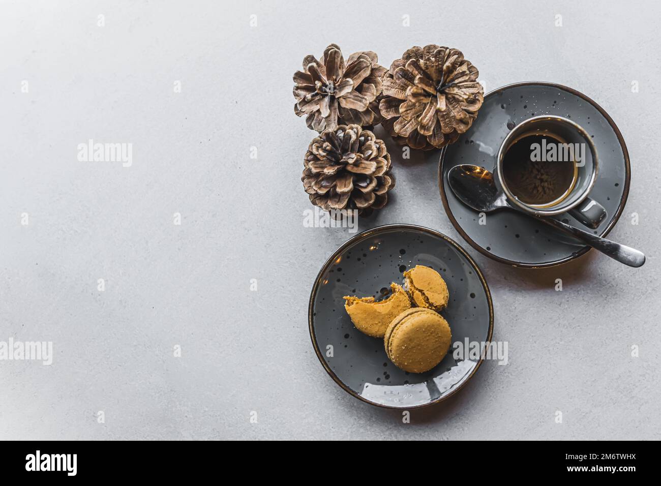 Makronen und Espresso in einem Becher neben drei Baumkegeln. Speicherplatz kopieren. Draufsicht. Hochwertiges Foto Stockfoto