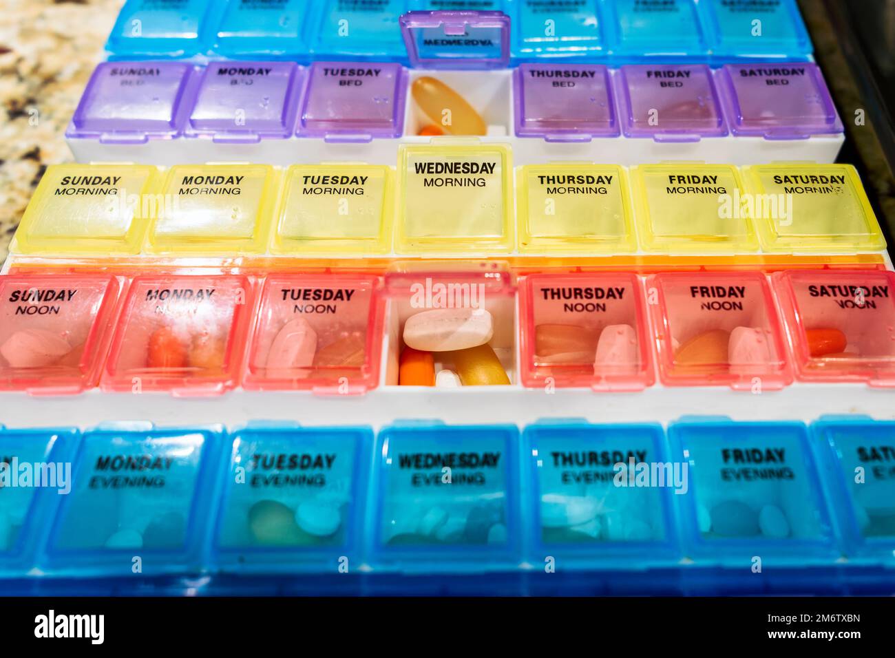 Mehrfarbige verschreibungspflichtige Pillen oder Medikamente oder Vitamin- oder Ergänzungsbox für tägliche Medikamentendosen. Stockfoto