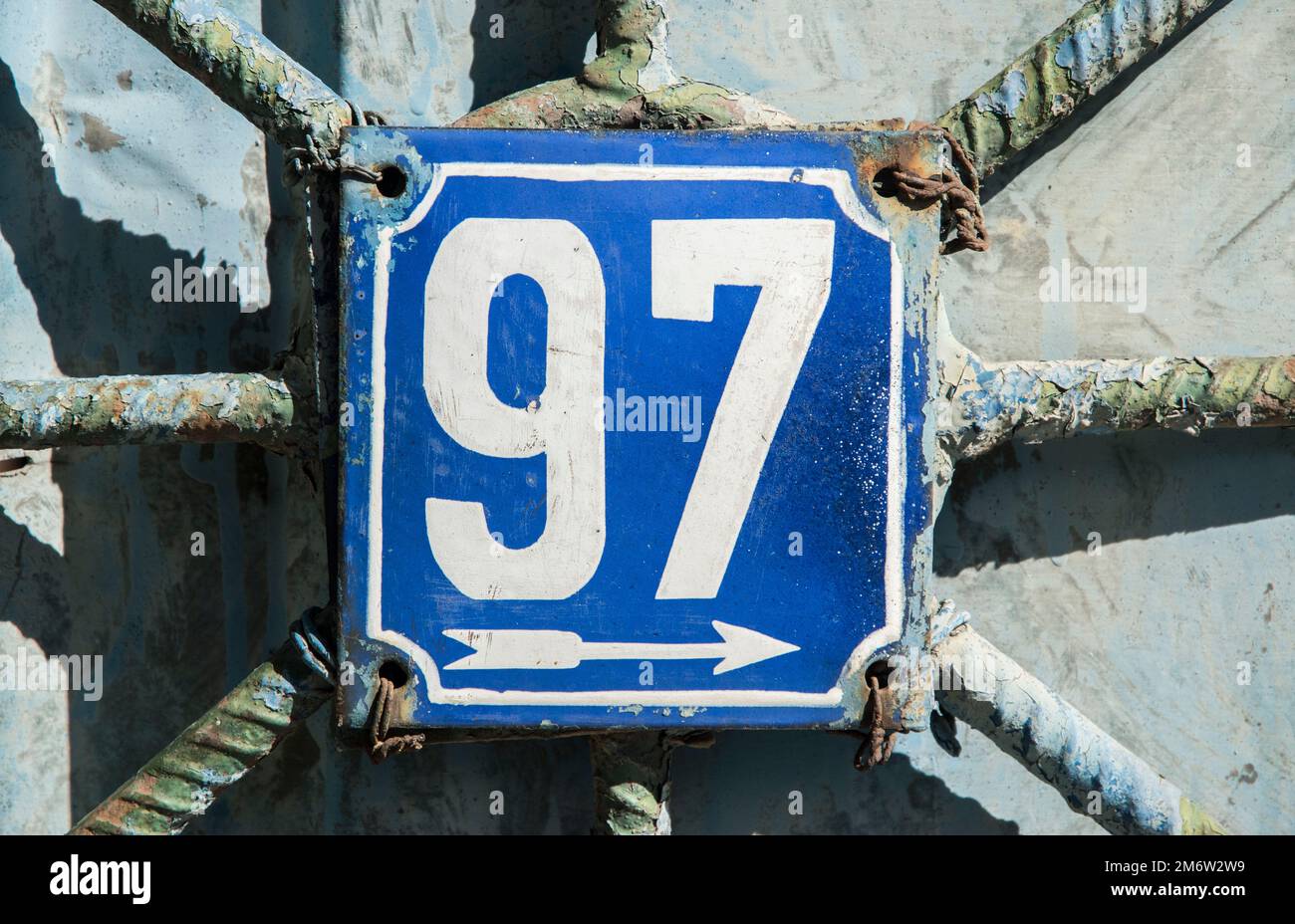 Verwitterte Grunge quadratisch metallisch emaillierte Platte der Nummer der Straße mit der Nummer 97 Stockfoto