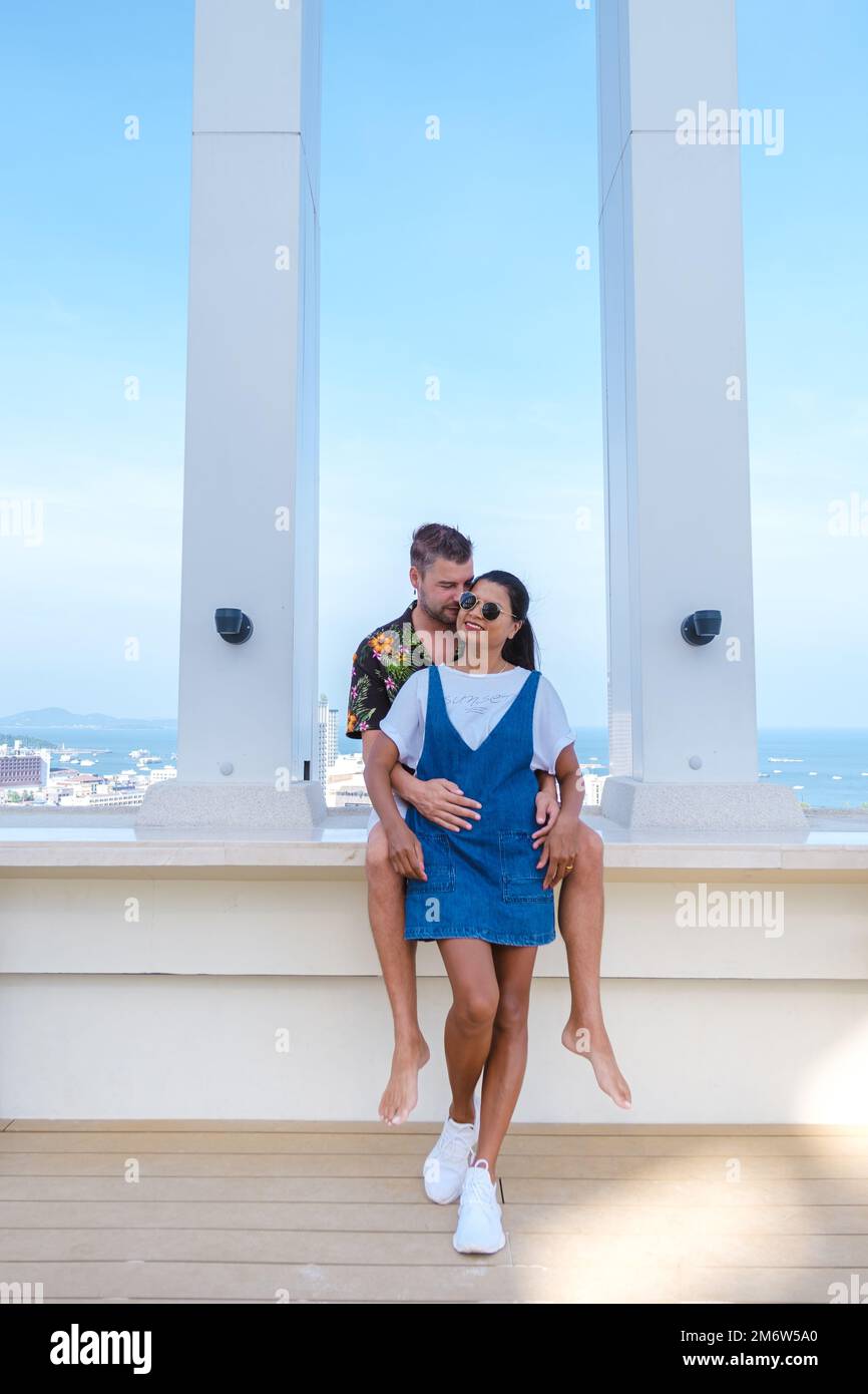 Ein Paar Männer und Frauen auf dem Dach eines Luxushotels mit Blick auf die Skyline der Stadt während des Urlaubs Stockfoto