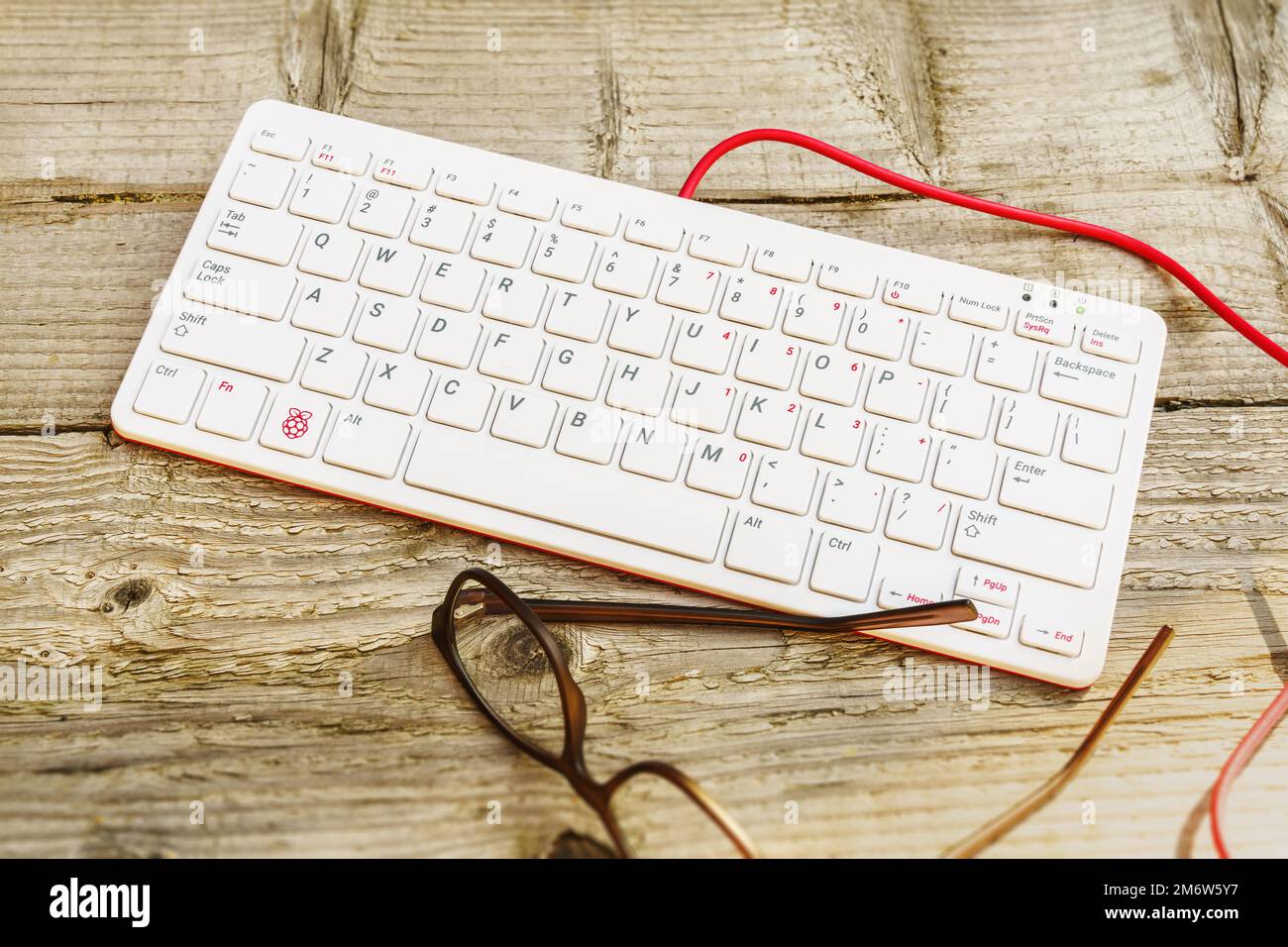 Raspberry Pi 400 Tastatur für den Außenbereich auf einem Holztisch mit Brille Stockfoto