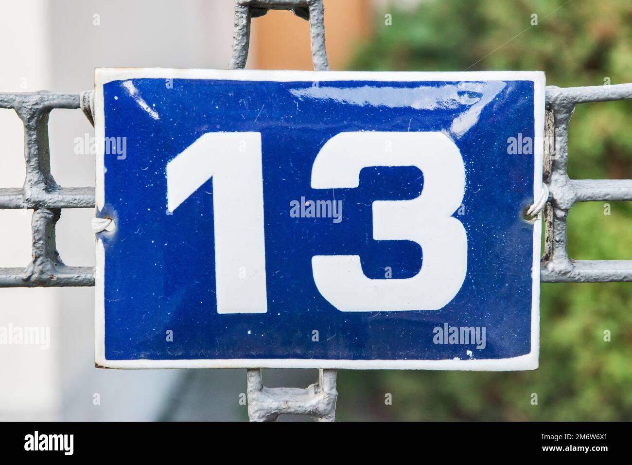 Verwitterte Grunge quadratisch metallisch emaillierte Platte der Nummer der Straße mit der Nummer 13 Stockfoto