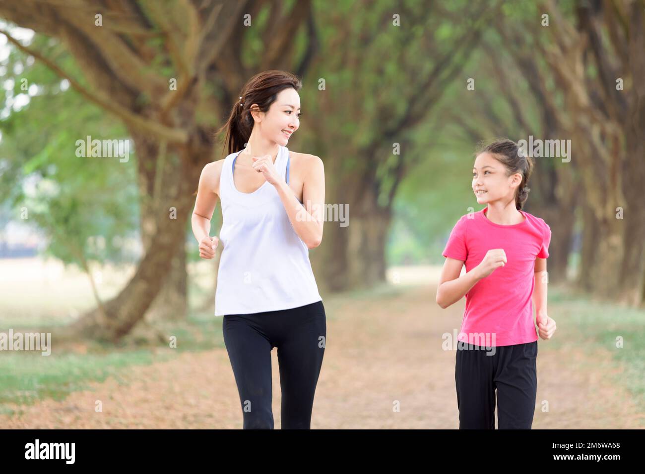 Glückliche Mutter und Tochter beim Joggen im Park Stockfoto