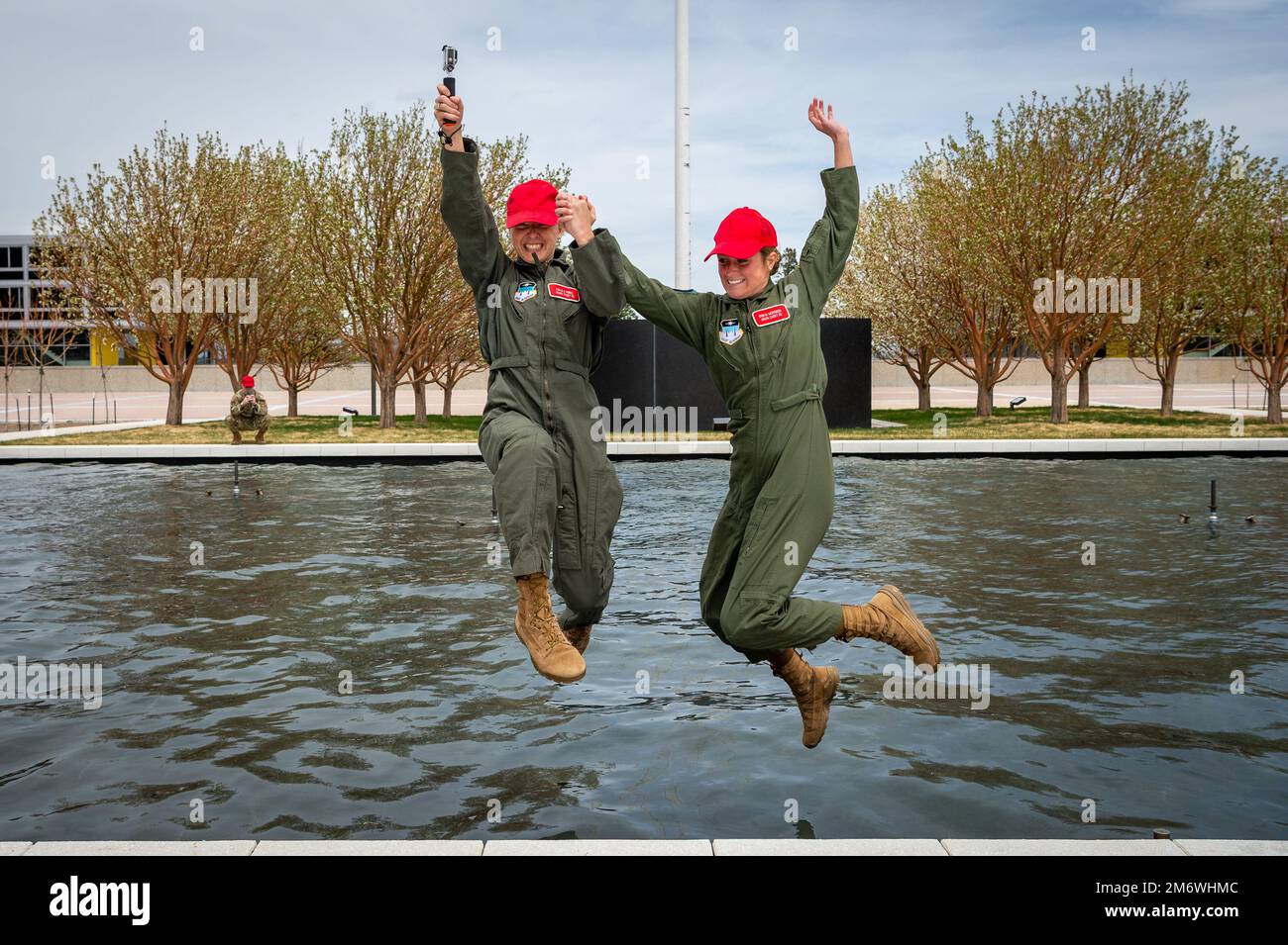 USA AIR FORCE ACADEMY, COLORADO -- vor ihrer nächsten Abschlussfeier setzten die Kadetten der Air Force Academy Kayla Perez, Left, und Erin Morrison ihre Tradition fort, in die Springbrunnen des Terazzo Air Garden zu springen, um den Abschluss der Abschlussprüfung am 6. Mai 2022 zu feiern. Stockfoto