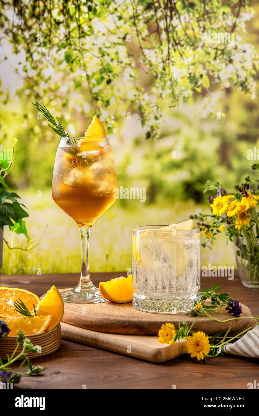 Zwei farbenfrohe Sommercocktails auf einem Holztisch. Starke Seltercocktails mit verschiedenen Früchten: Orange, Zitrone. Outdoor Sommer Par Stockfoto