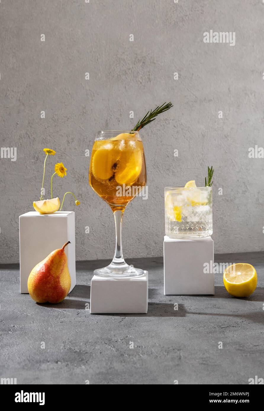 Sommercocktails auf den weißen Podien. Harte Seltercocktails mit Zitrone und Birne. Stockfoto