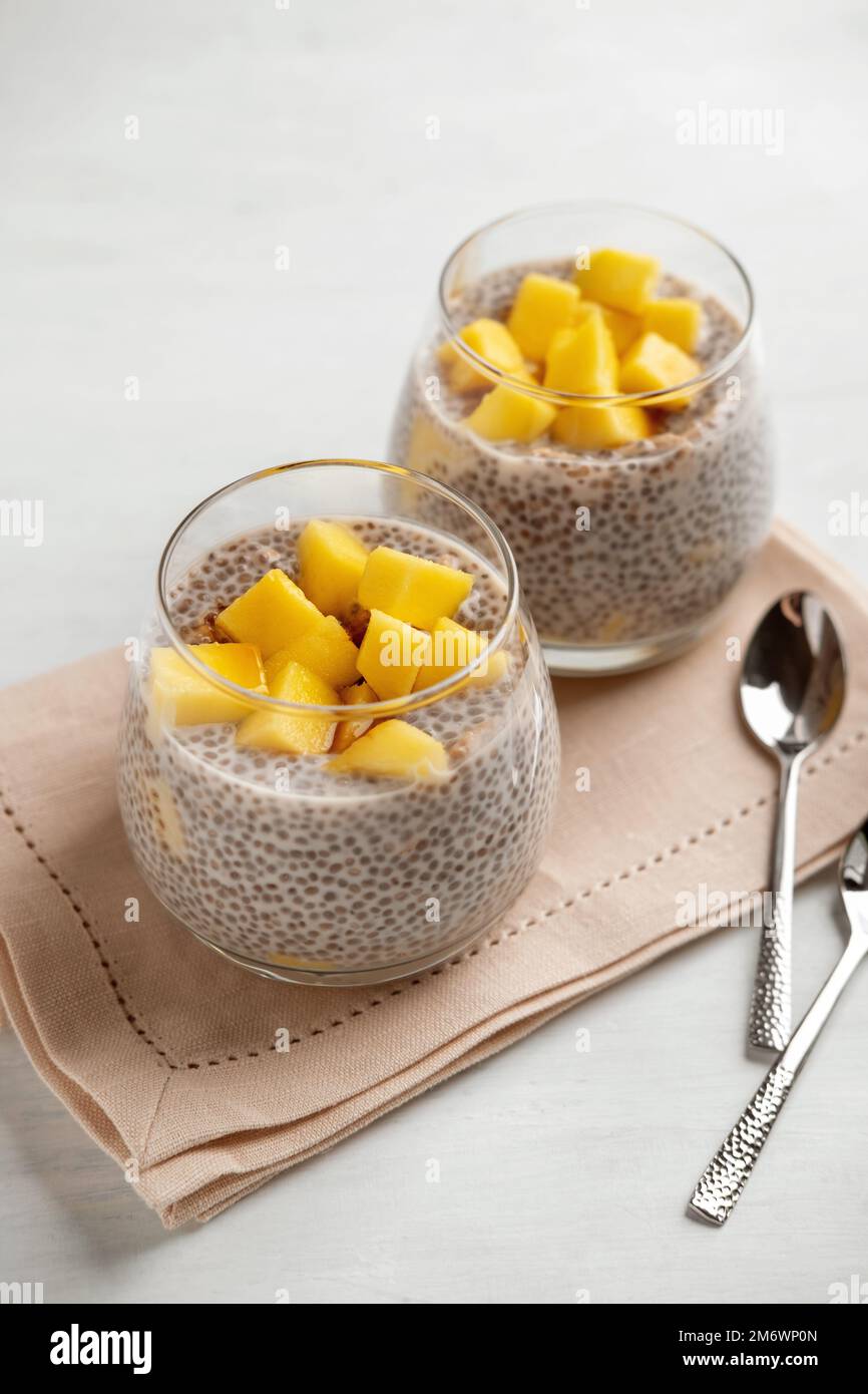 Veganer Chia-Kokosnuss-Pudding mit Mango auf weißem Hintergrund. Gesunde Ernährung, Superfood. Großansicht. Stockfoto