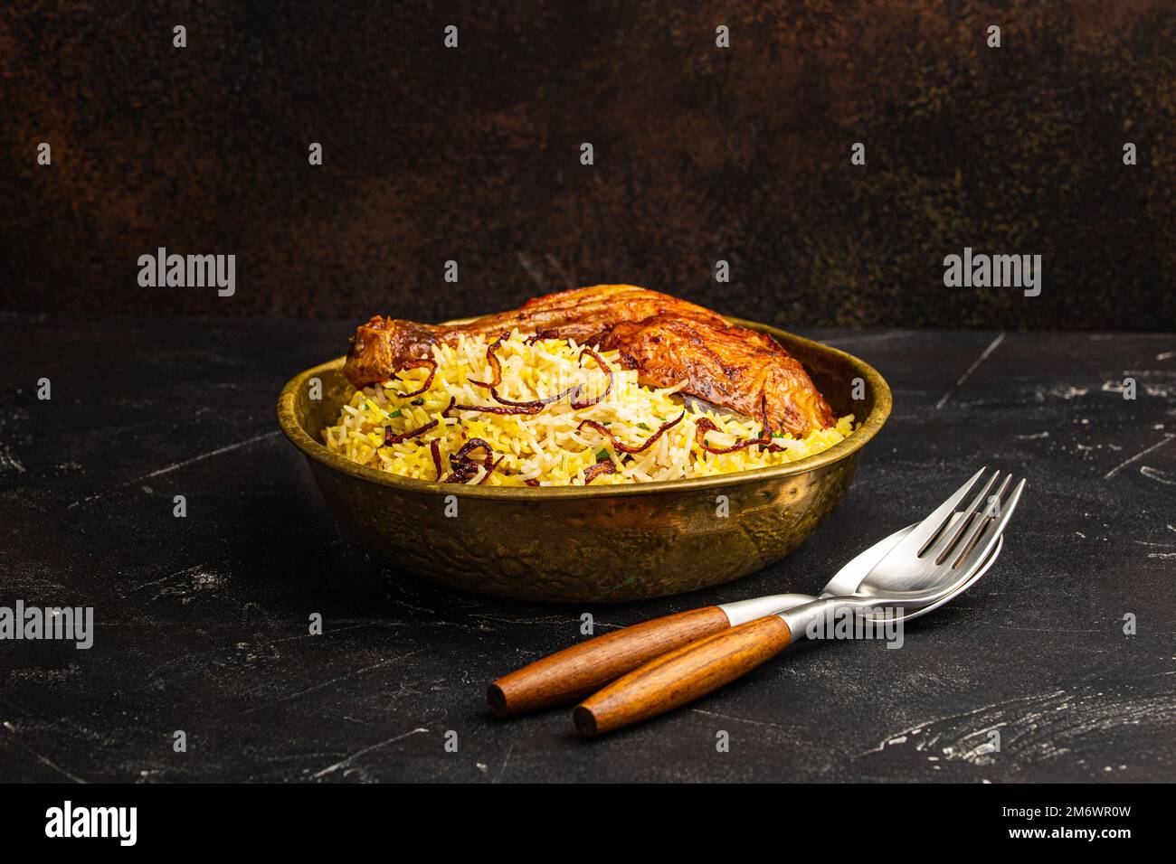 Indisches Gericht Biryani Huhn mit Basmati-Reis in Metall Messing alte Schüssel auf dem Tisch Stockfoto