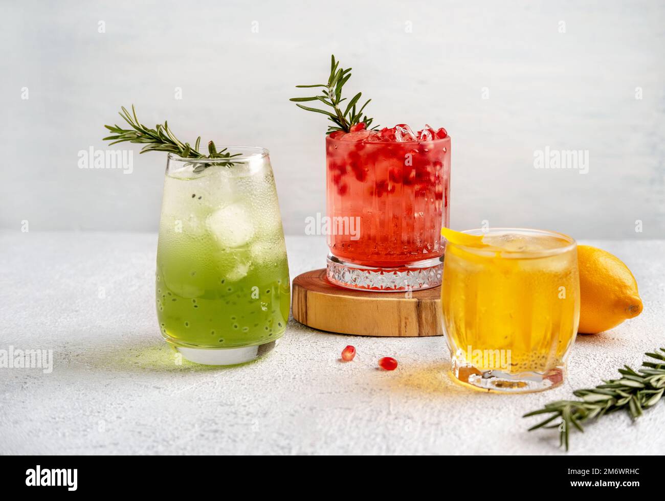 Drei farbenfrohe Sommercocktails in Gläsern auf einem weißen Tisch. Auswahl an frischen Sommergetränken. Rote Sangria-Cocktails, orangefarbenes pu Stockfoto