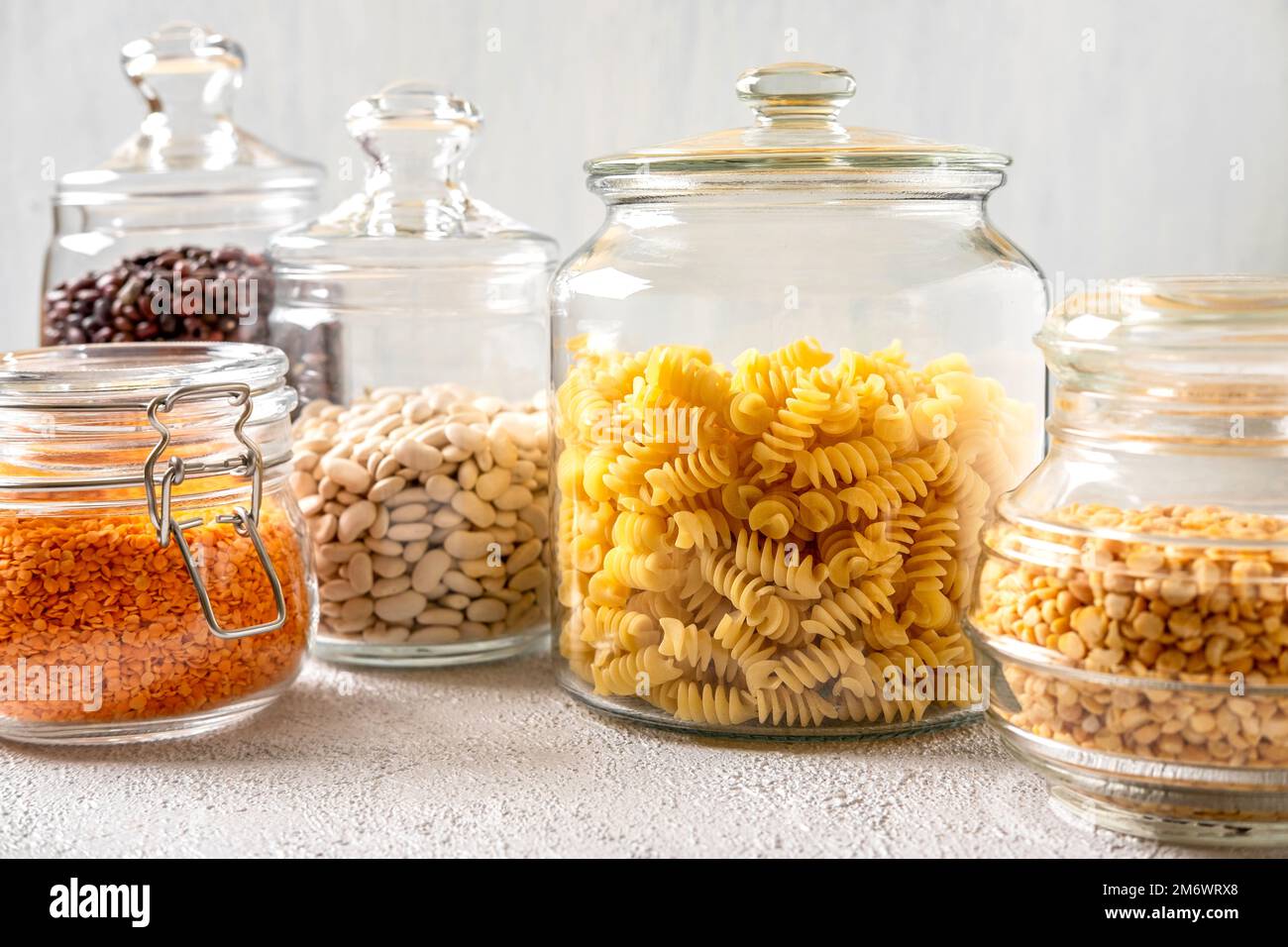 Verschiedene Hülsenfrüchte in Glasgefäßen: Kichererbsen, Pasta, Bohnen, Erbsen, Linsen. Keine Abfalllagerung, plastikfrei. Stockfoto