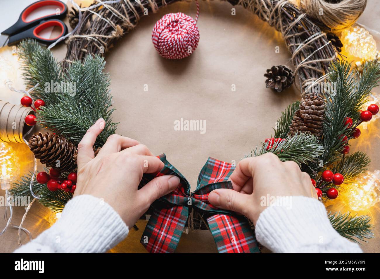 Einen Weihnachtskranz mit eigenen Händen machen. Feiertagsvorbereitung, Hausdekoration, Neujahr Stockfoto