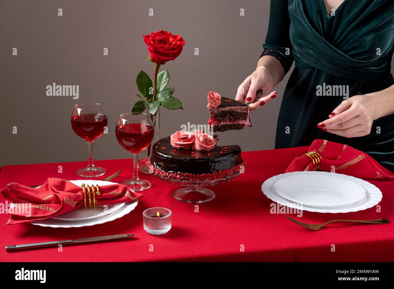 Abendessen am Valentinstag mit Tischdecken, Rotwein, Kerzen und Schokoladenkuchen. Romantische Valentinstagsfeier Stockfoto