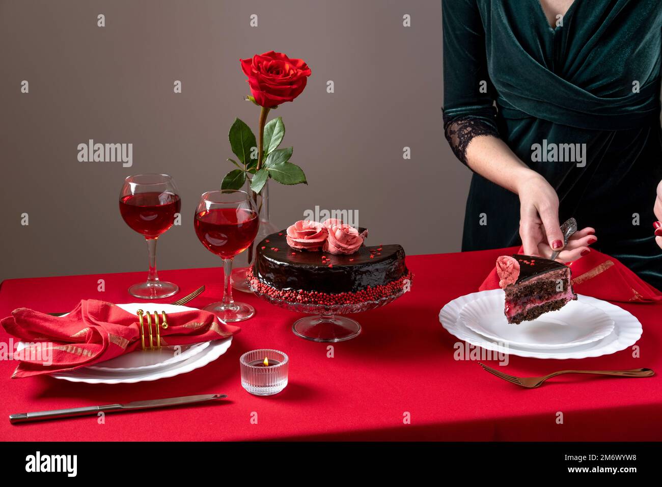 Abendessen am Valentinstag mit Tischdecken, Rotwein, Kerzen und Schokoladenkuchen. Romantische Valentinstagsfeier Stockfoto
