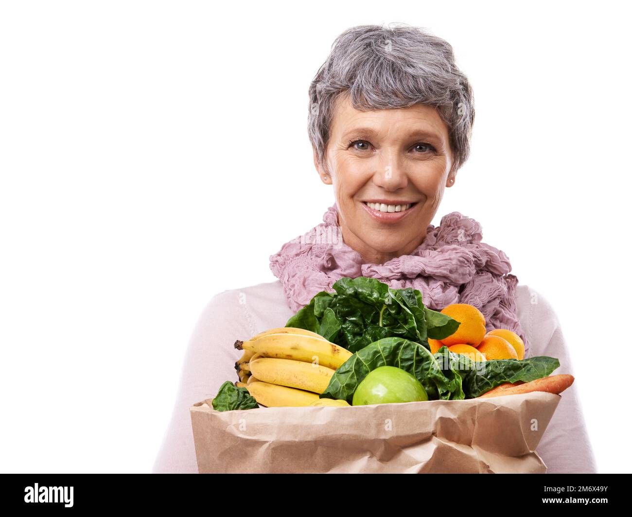 Leben auf gesunde Weise. Studioporträt einer erwachsenen Frau mit einer braunen Papiertüte gefüllt mit Obst und Gemüse. Stockfoto