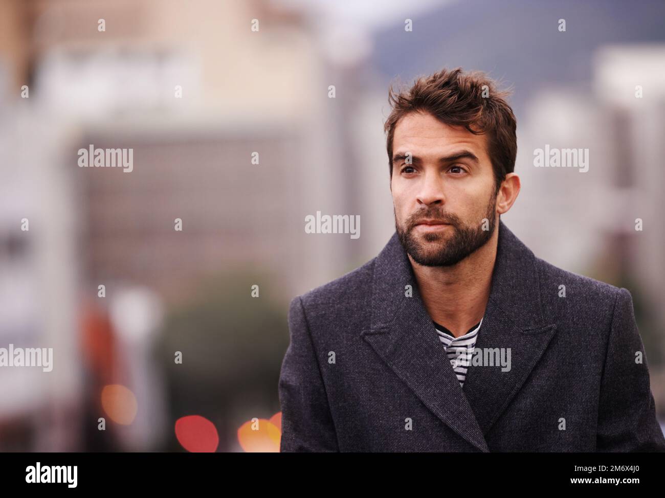 Stadtdesign. Ein gutaussehender junger Mann, der durch die Stadt spaziert. Stockfoto