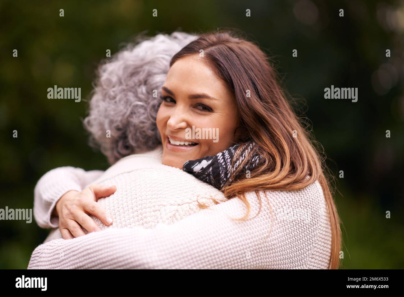 Umarmungen helfen bei allem. Eine Frau umarmt ihre ältere Mutter draußen. Stockfoto