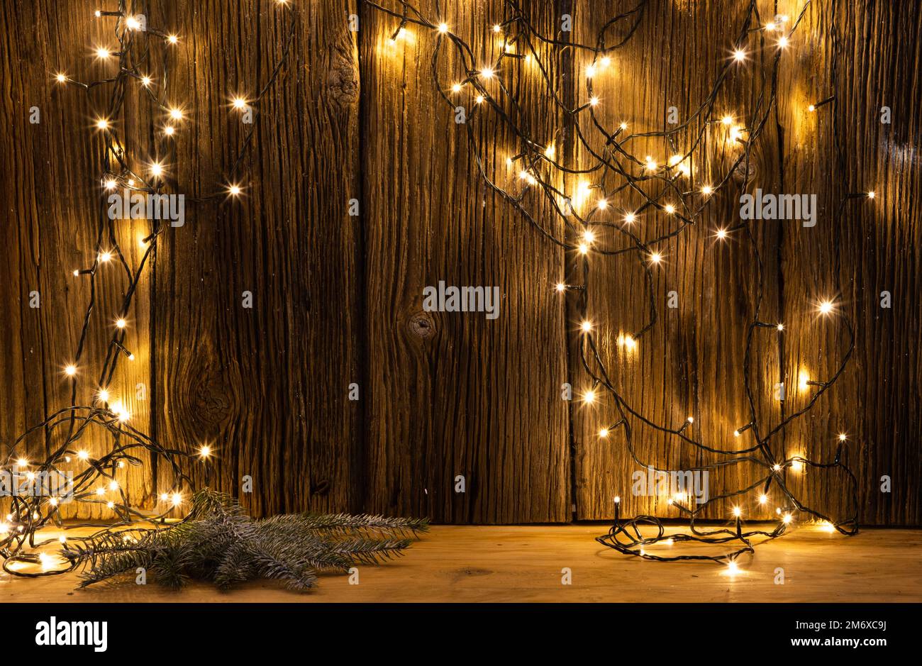 Weihnachtsbeleuchtung und Dekorationen auf Holzhintergrund Stockfoto