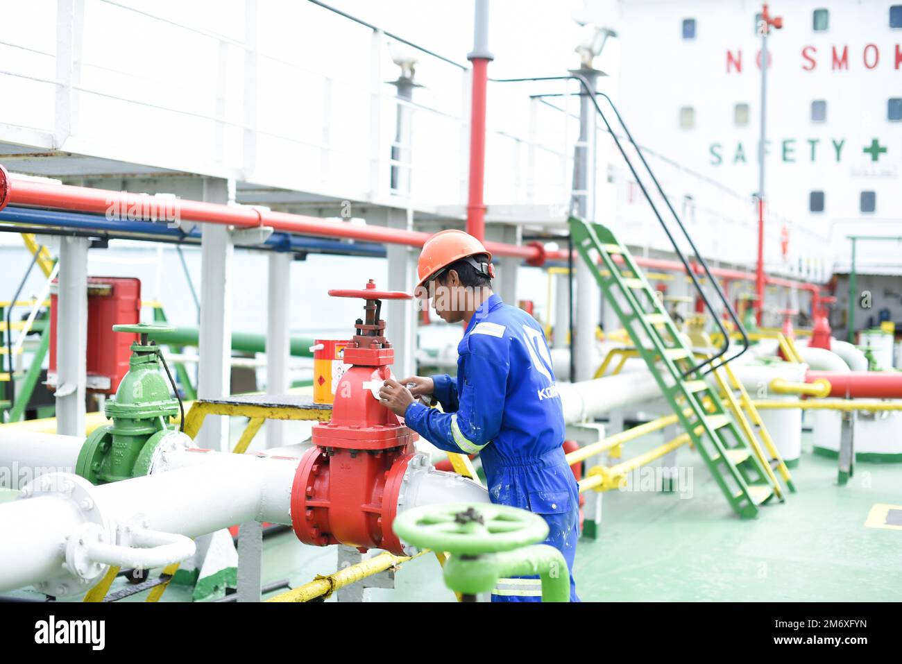 Banten, Indonesien, 15. November 2022: Besatzungsmitglieder, die chemische Rohrventile an Bord von Schiffen im Freien überprüfen. Schiffsinstandhaltungskonzept. Teamwork-Konzept. Stockfoto