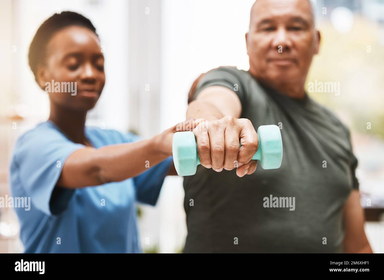 Medizin, Training und Physiotherapie mit Kurzhantel und alter Mann mit Krankenschwester zur Rehabilitation, Unterstützung und Pensionierung. Gesundheit, Hilfe und körperliche Stockfoto