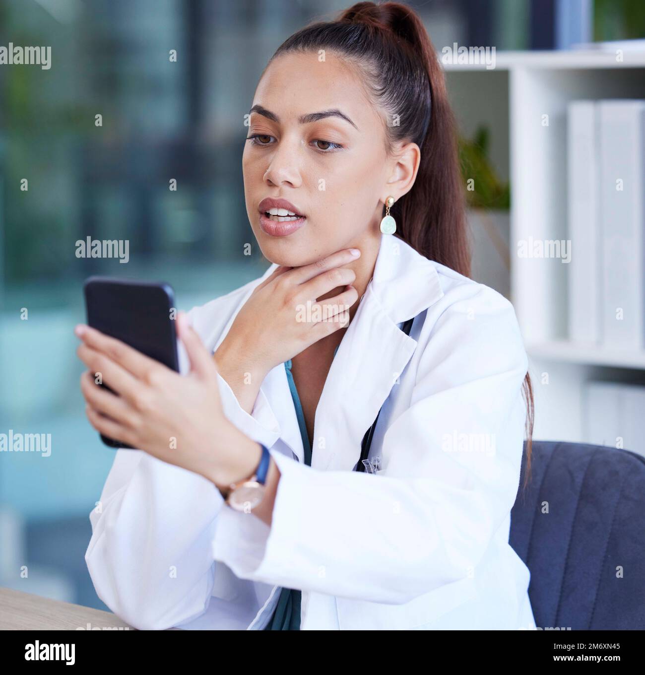 Telefon, Videoanruf und Ärztin, die eine Online-Beratung für das Gesundheitswesen in ihrer Praxis im Krankenhaus durchführt. Kommunikation, Technologie und weibliche Medizin Stockfoto