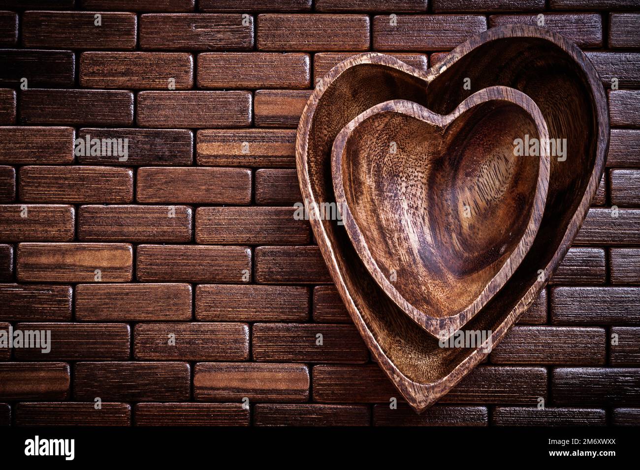 Herzförmige Schüsseln auf Holzmatte für Speisen und Getränke. Stockfoto