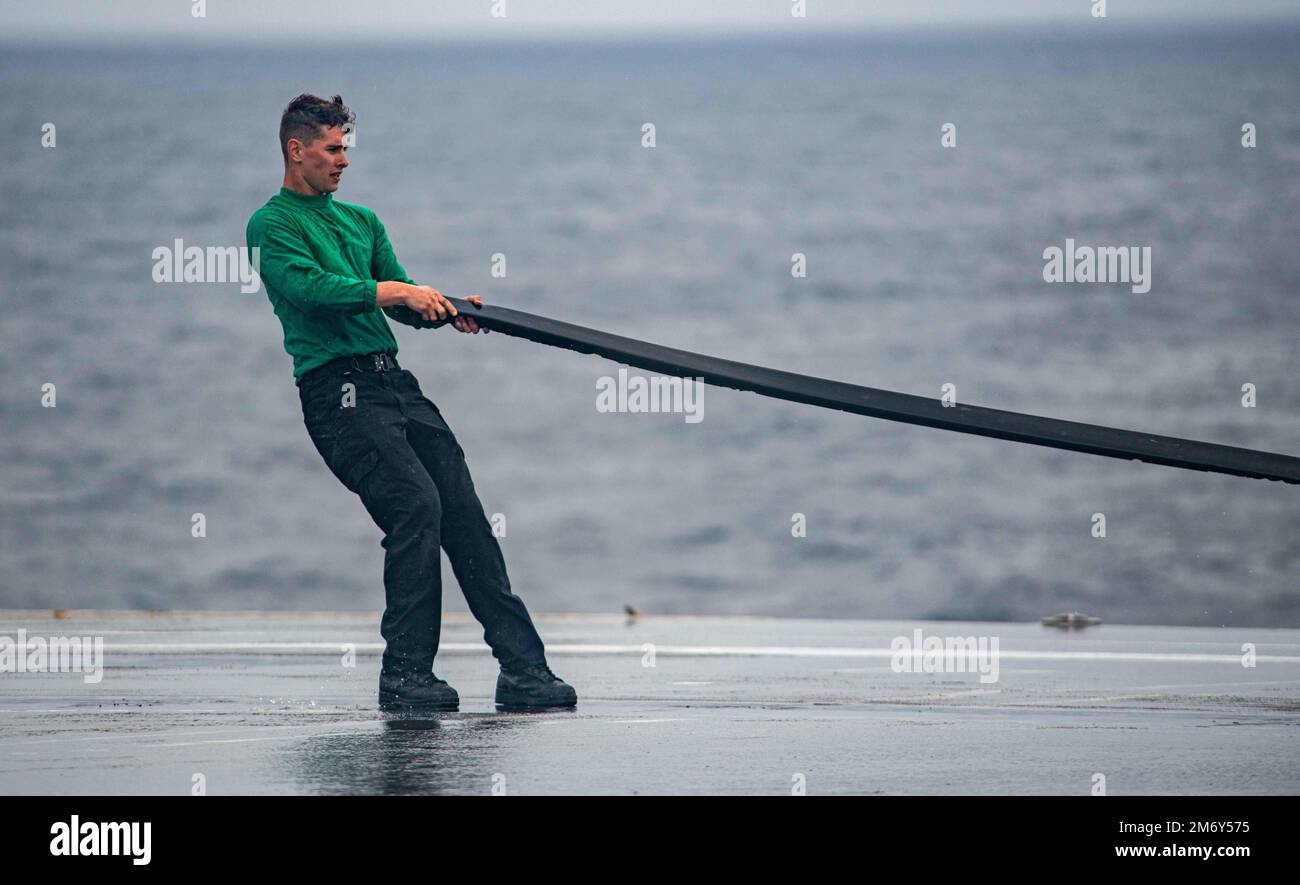 220510-N-DW158-1060 PACIFIC OCEAN (10. Mai 2022) Aviation Boatswain’s Mate (Equipment) Airman Zachary Dahl aus Pleasant Hill, Oregon, legt eine Gummiabdeckung über ein Katapult auf dem Flugdeck der USA Der einzige nach vorn eingesetzte Flugzeugträger der Navy USS Ronald Reagan (CVN 76), der während eines Tests des Abwaschsystems für Gegenmaßnahmen am Schiff eingesetzt wurde. Das Abwaschsystem für Gegenmaßnahmen wird vor, während und nach einer chemischen Kontamination verwendet, um schädliche Chemikalien oder Agenzien an der Außenseite des Schiffes zu entfernen. Ronald Reagan, das Flaggschiff der Carrier Strike Group 5, stellt eine kampfbereite Truppe bereit, die diese Prote unterstützt Stockfoto