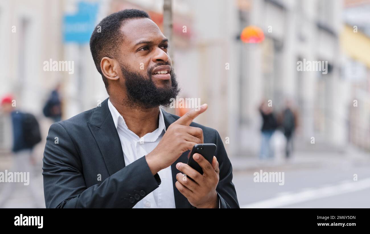 Nahaufnahme eines bärtigen afroamerikanischen Mannes mit Smartphone, der die Navigationsanwendung verwendet, GPS-Service Suche Adresse verloren in der Stadt gesucht mit Stockfoto