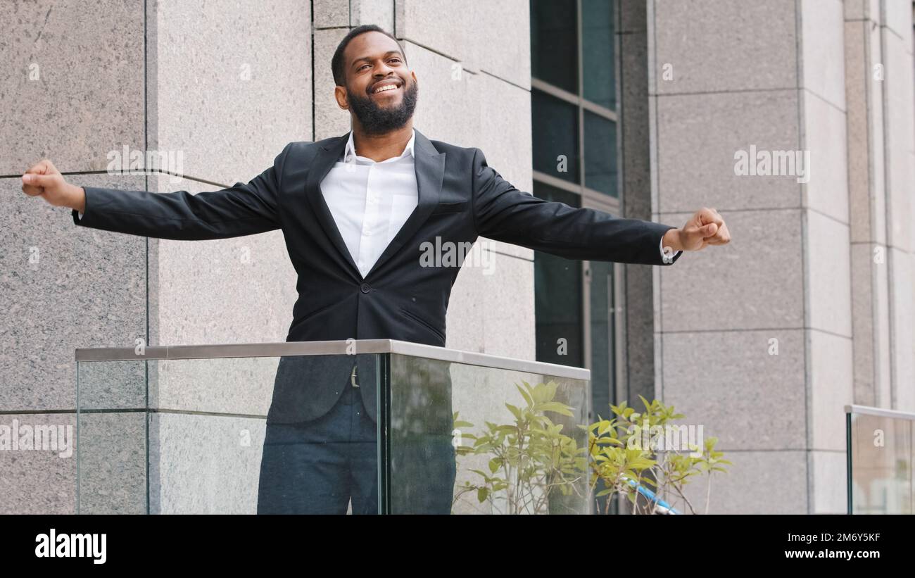 Überglücklich glücklich lustig lustig fröhlich afroamerikanischer Angestellter Unternehmer Unternehmer Unternehmer Arbeiter Mann steht auf dem Bürobalkon und tanzt entspannend Stockfoto