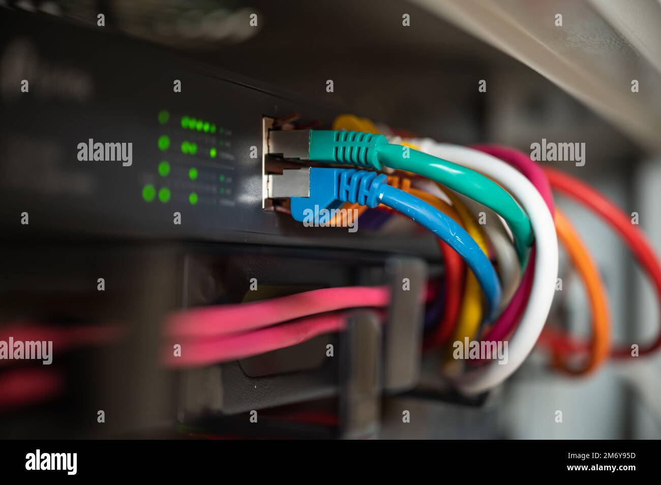 Switch mit bunten LAN-Kabeln in einem Netzwerkschrank eines Rechenzentrums Stockfoto