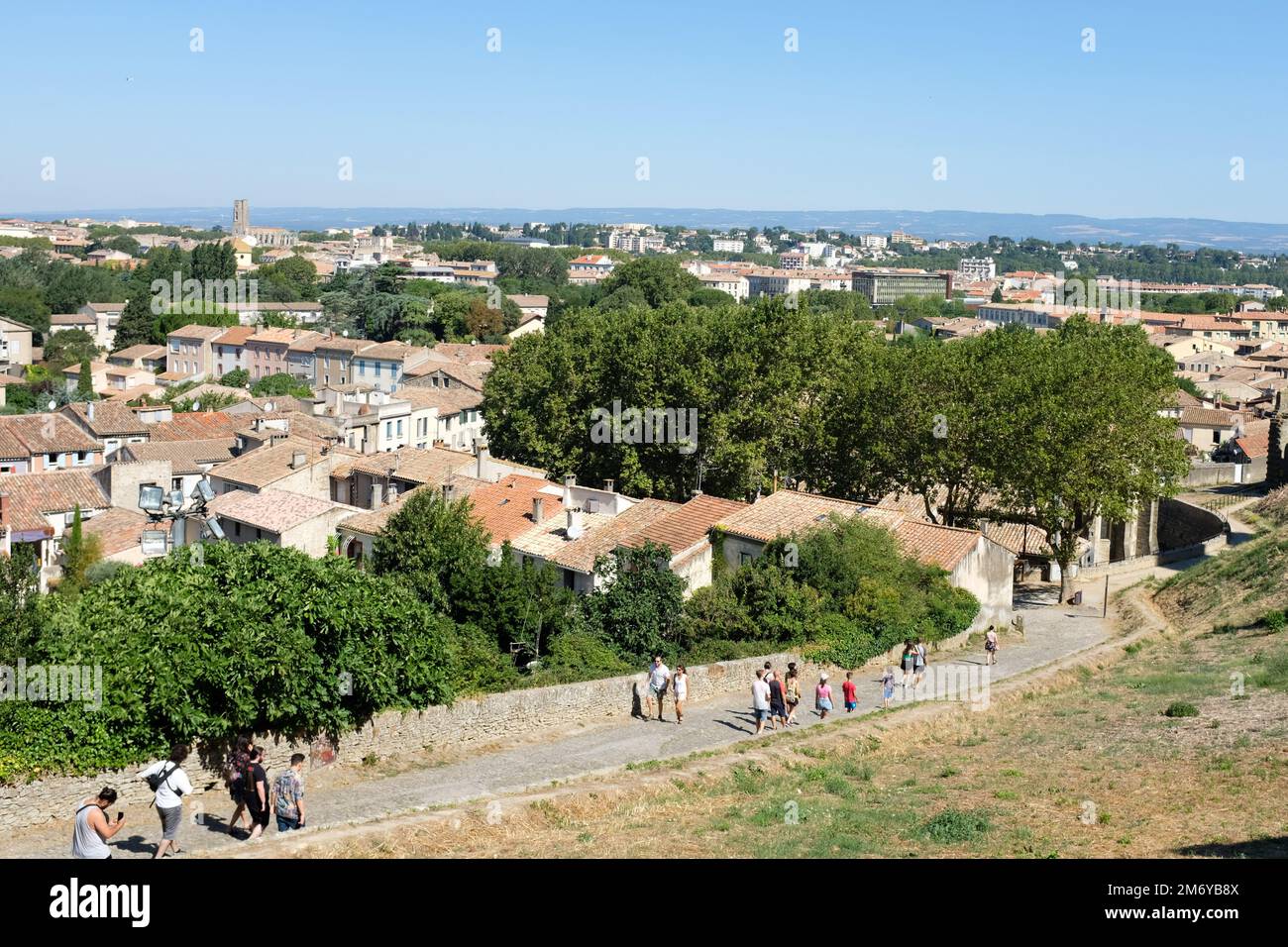 Carcassonne, Frankreich - Touristen gehen von der alten, auf einem Hügel gelegenen Festung hinunter ins Zentrum von Carcassonne. 2022. Stockfoto