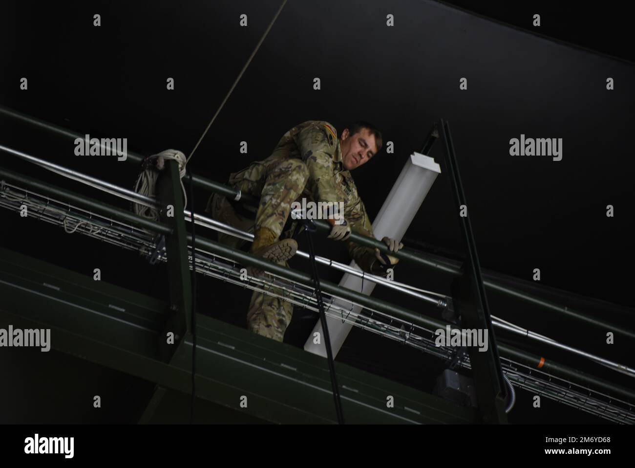 Der Armeeoffizier Jamie Koopman klettert über das Laufsteg an der Decke des Tyson Events Center in Sioux City, Iowa, während er sich am 10. Mai 2022 über den Rand abseilt. Der Soldat der Nationalgarde Iowa wurde beauftragt, den Puck zu Beginn der Playoff-Auseinandersetzung der Sioux City Musketeers Hockey Western Conference am Dienstagabend zu liefern. USA Air National Guard Foto Senior Master Sgt. Vincent De Groot Stockfoto