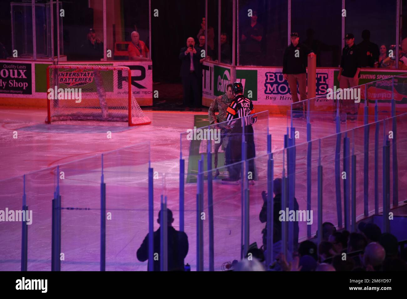 Nachdem er sich vom Decken Army Staff Sgt. Jamie Koopman abseilt, liefert er dem Beamten im Tyson Events Center in Sioux City, Iowa, den Puck vor dem Start des Playoff-Treffens der Sioux City Musketeers Hockey Western Conference am 10. Mai 2022. Der Soldat der Nationalgarde Iowa wurde beauftragt, den Puck zu liefern, nachdem er zu Beginn der Playoff-Auseinandersetzung der Sioux City Musketeers Hockey Western Conference am Dienstagabend von den Sparren abstieg. USA Air National Guard Foto Senior Master Sgt. Vincent De Groot Stockfoto