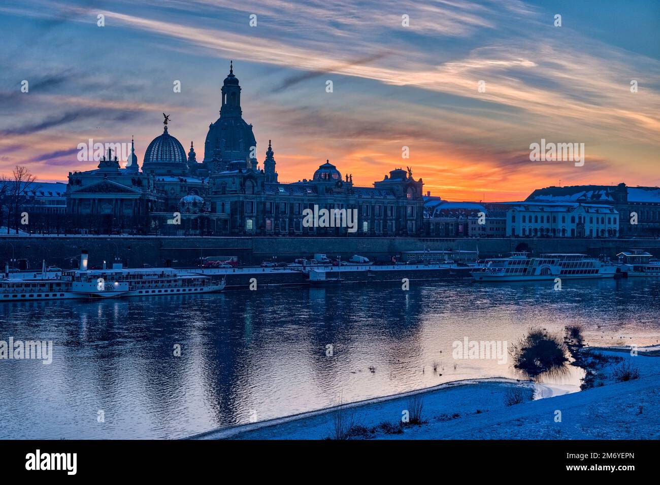 Roter Sonnenuntergang über der Kirche unserer Lieben Frau und dem Albertinum in der Altstadt, über die Elbe zu sehen. Stockfoto