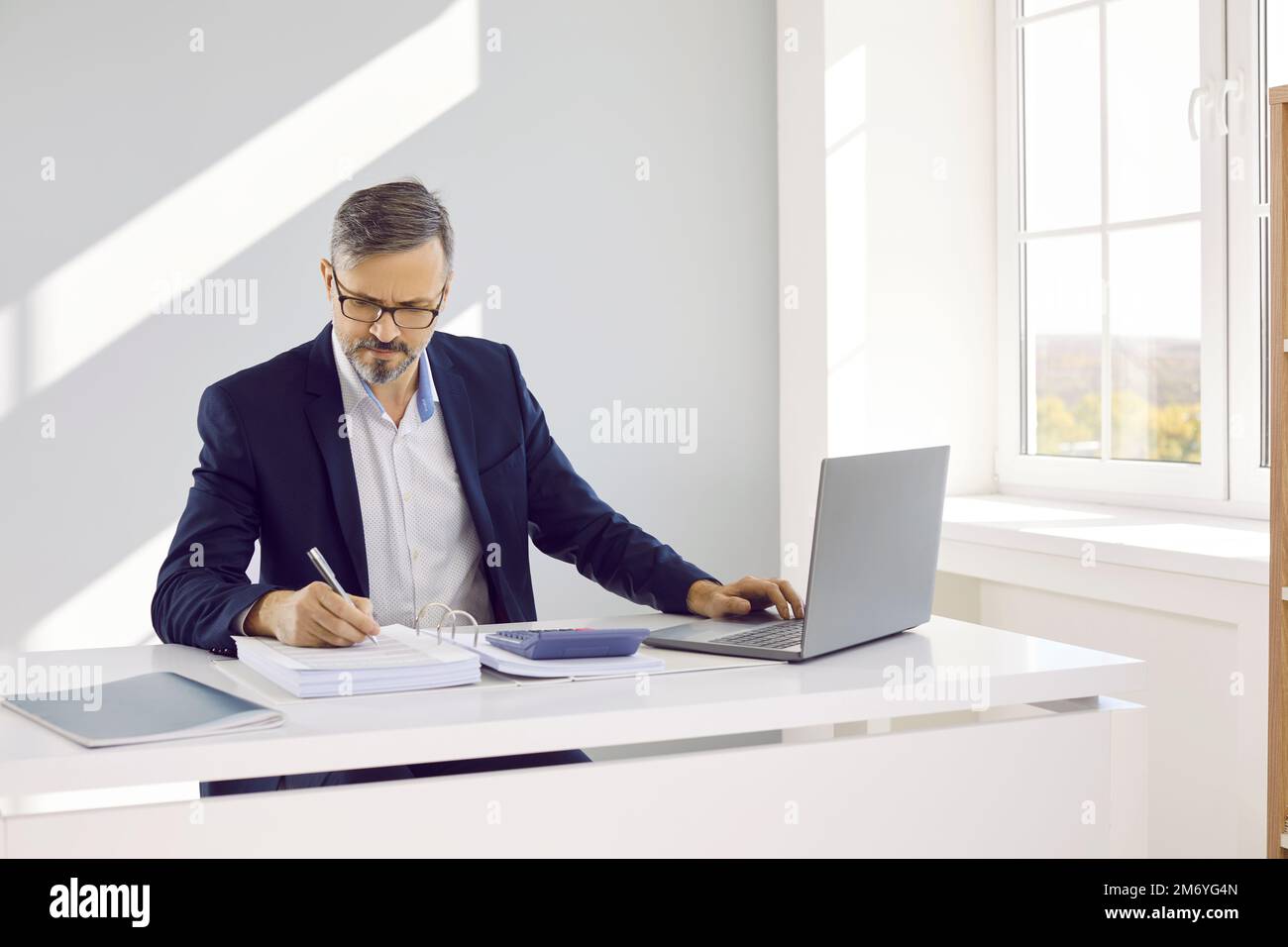 Geschäftsmann, Wirtschaftsprüfer oder Finanzbuchhalter, der im Büro an einem Laptop arbeitet Stockfoto