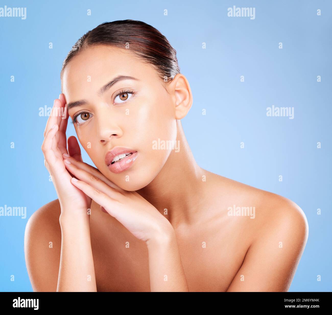 Porträt, Frauen- und Hautpflege auf blauem Studiohintergrund für Schönheitssalon, Körperschminke und Kosmetik. Junges Model, Gesichtsfoto und natürliches Leuchten Stockfoto