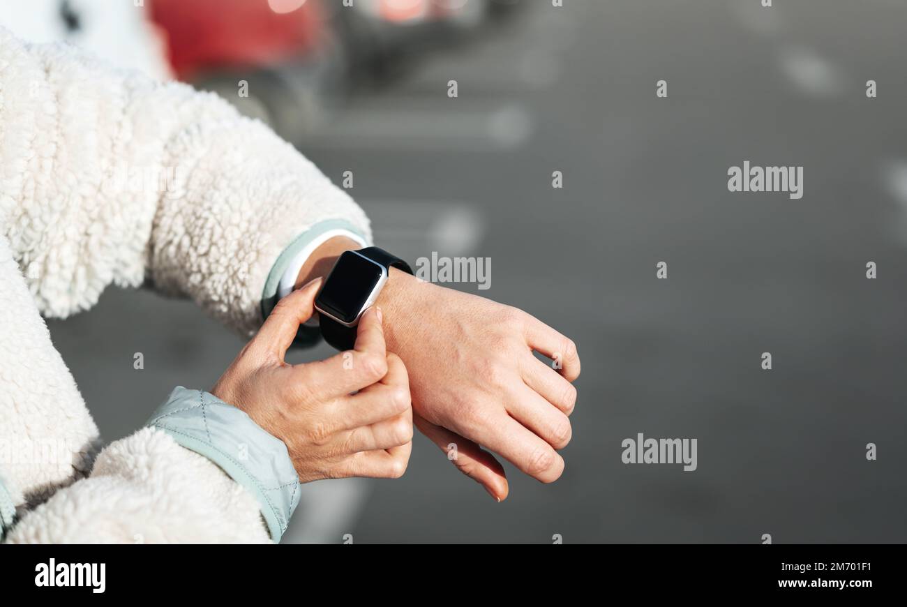 Weibliche Person, die ihre Smartwatch im Freien benutzt. Stockfoto