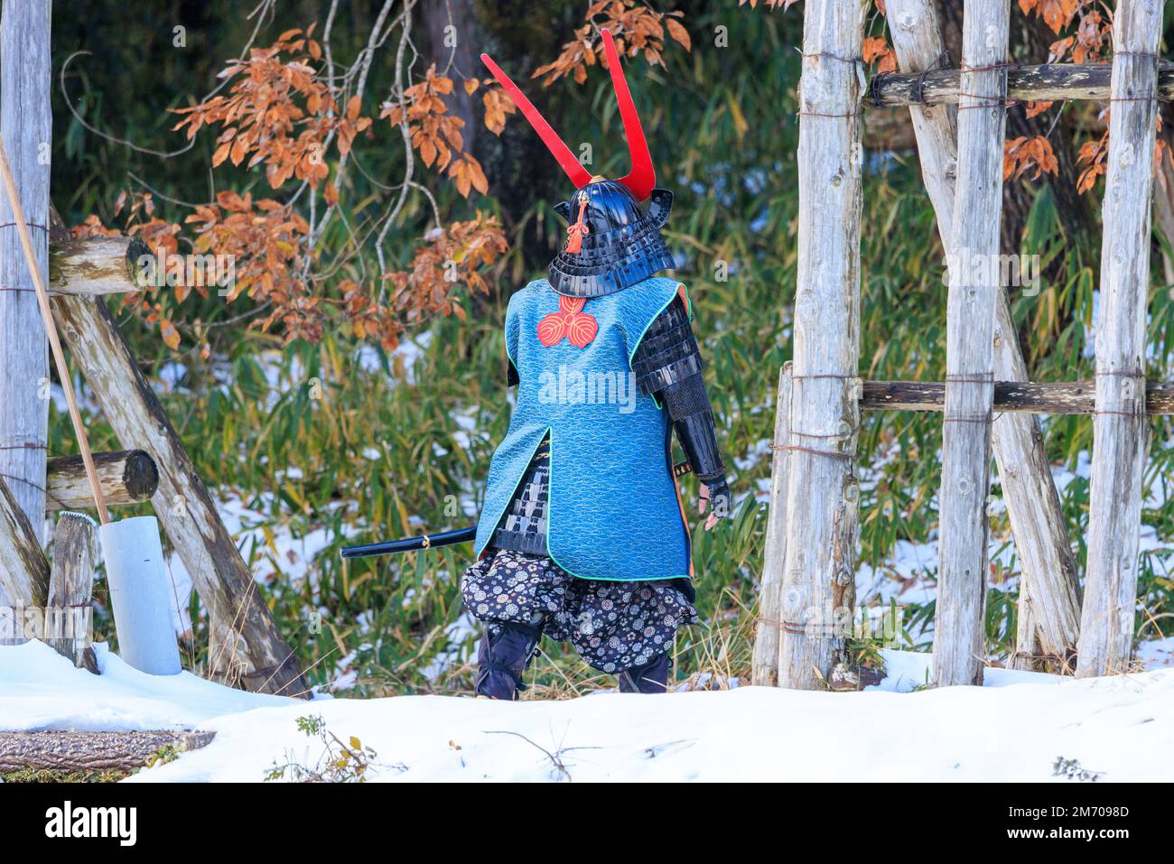 Ein Mann im traditionellen Samurai-Stil wandert durch den Schnee Stockfoto