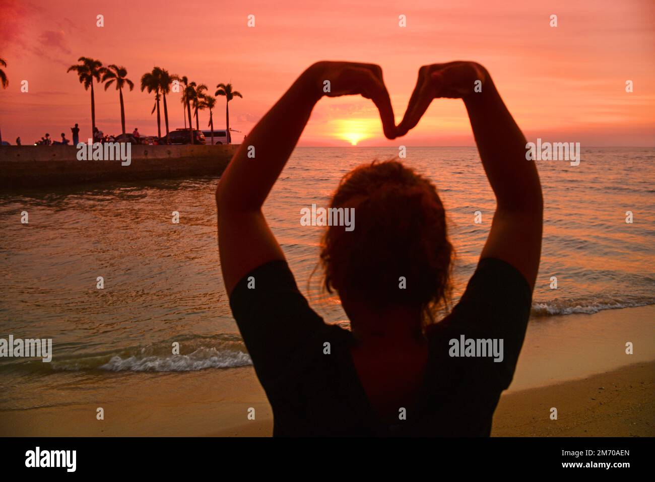 eine frau, die sich beim Sonnenuntergang in thailand das Herz geformt hat Stockfoto