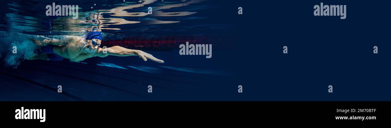 Dynamisches Porträt eines jungen Mannes, professionelles Schwimmertraining im Innenpool. Wettbewerbsvorbereitung Stockfoto