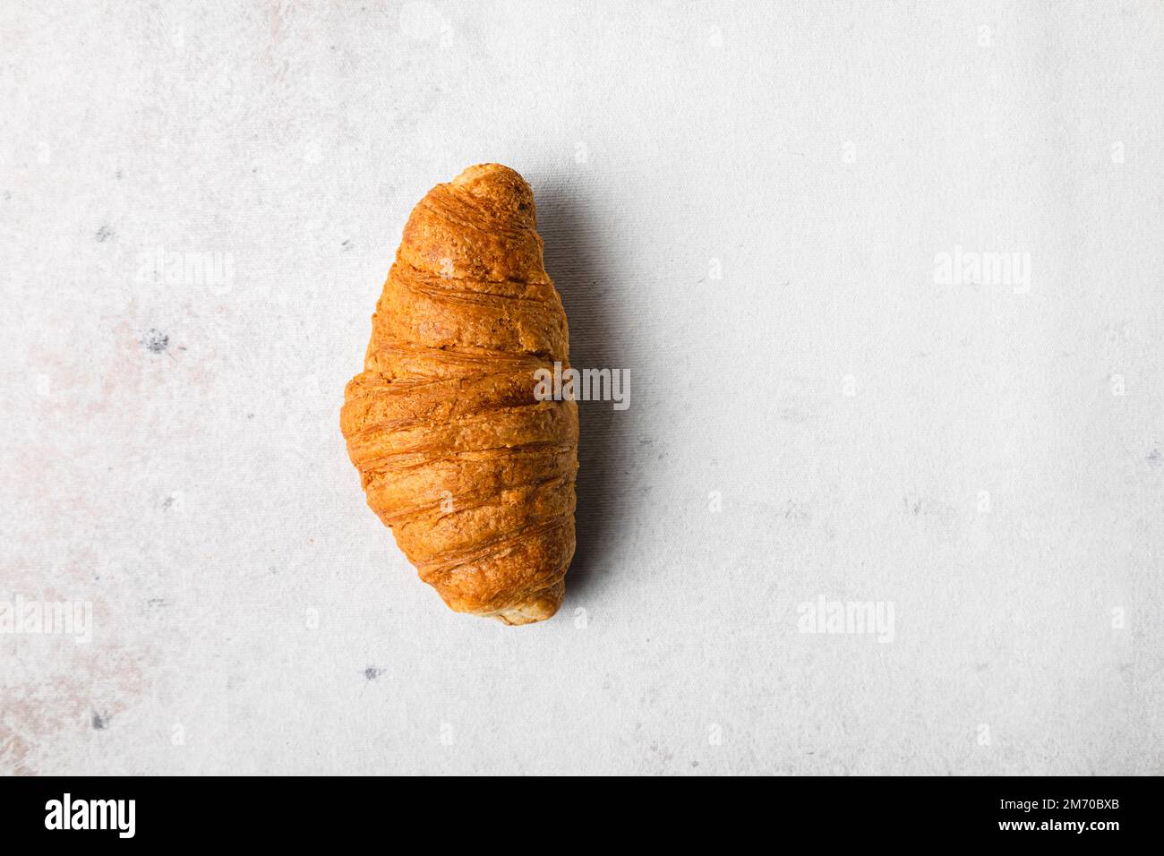Einzelnes Croissant auf weißem Hintergrund. Stockfoto