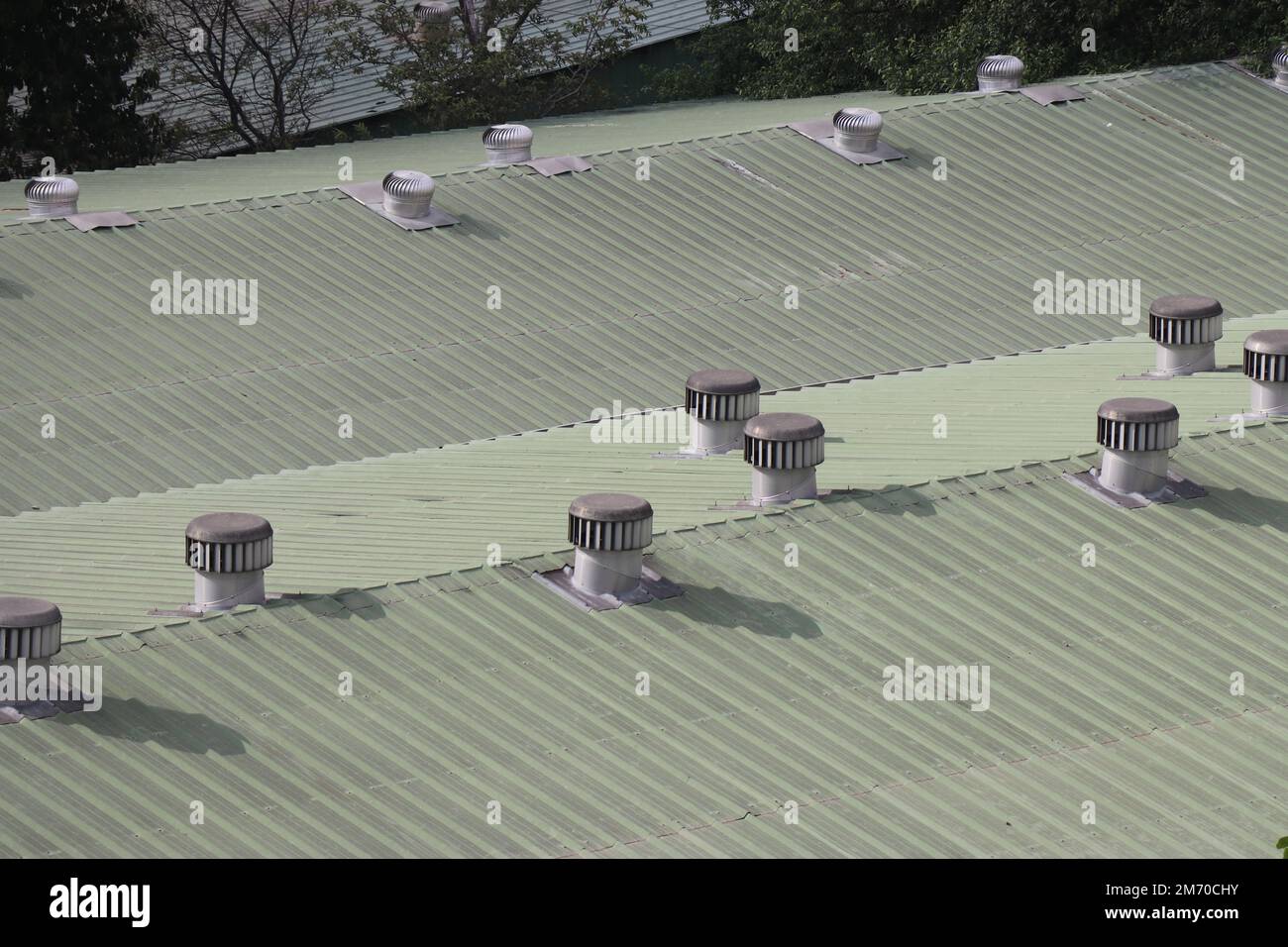 Ventilatoren, die nicht von Strom angetrieben werden, auf dem Dach einer kleinen Industrie. Ventilatoren auf dem Dach, die sich drehen und Wind ins Gebäude bringen Stockfoto