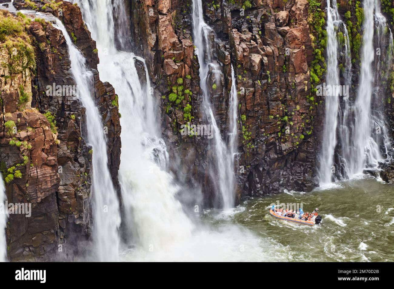Beliebte Touristenabenteuer an den Iguazu Falls, Schnellboot nähert sich dem Wasserlauf, Blick von der brasilianischen Seite Stockfoto