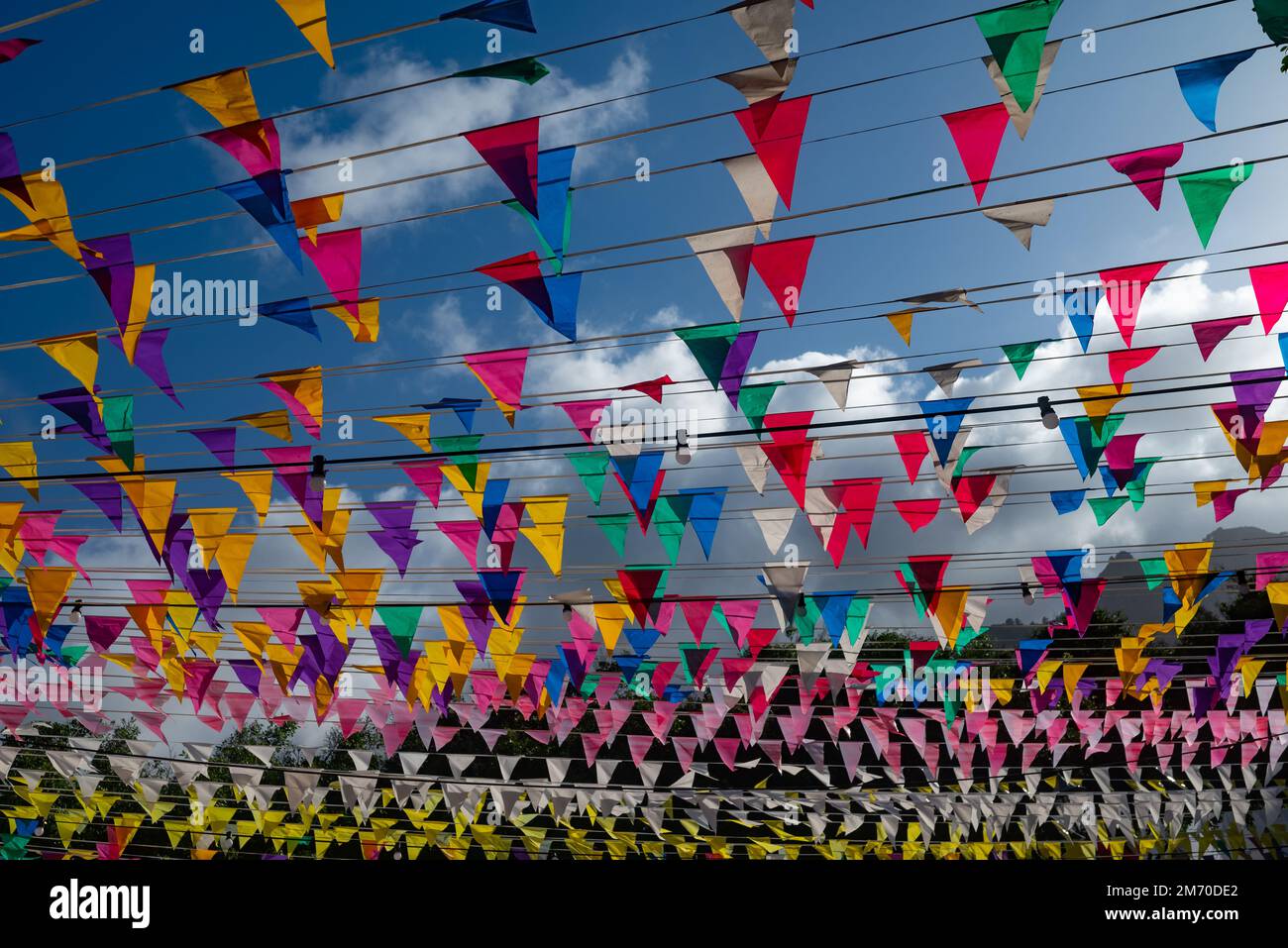 Festlicher Hintergrund mit bunten dreieckigen Flaggen auf blauem Himmelshintergrund Stockfoto