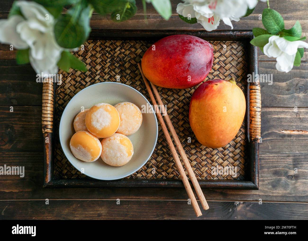 japanische Mango-Mochi-Kuchen mit Eiscreme auf einem klassischen asiatischen Holztablett Stockfoto