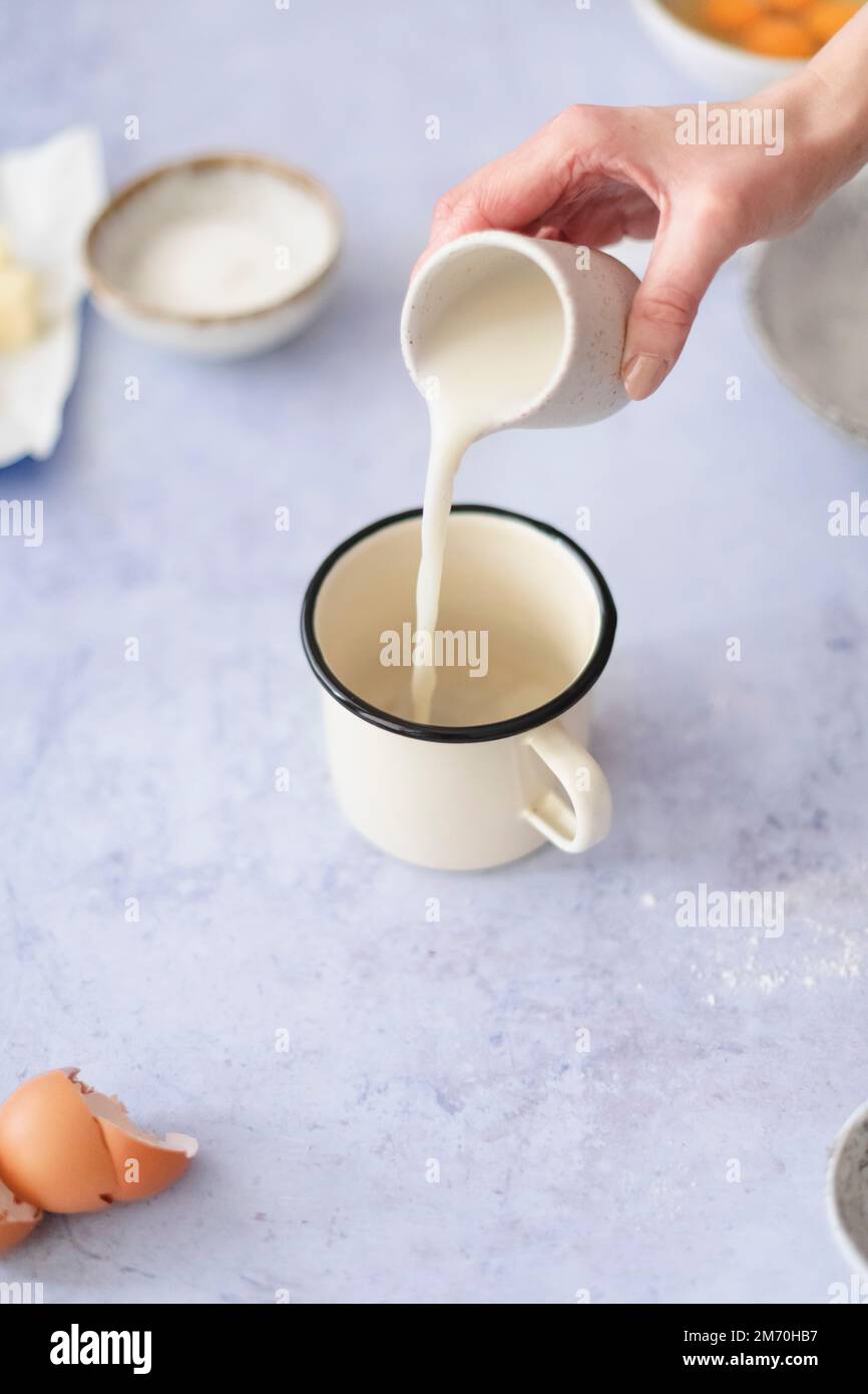 Milch in eine Tasse gießen Stockfoto
