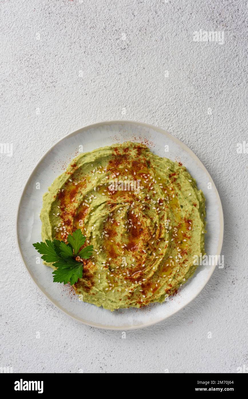Avocado hummus gewürzt mit Sesam, Paprika und Petersilie. Draufsicht. Stockfoto