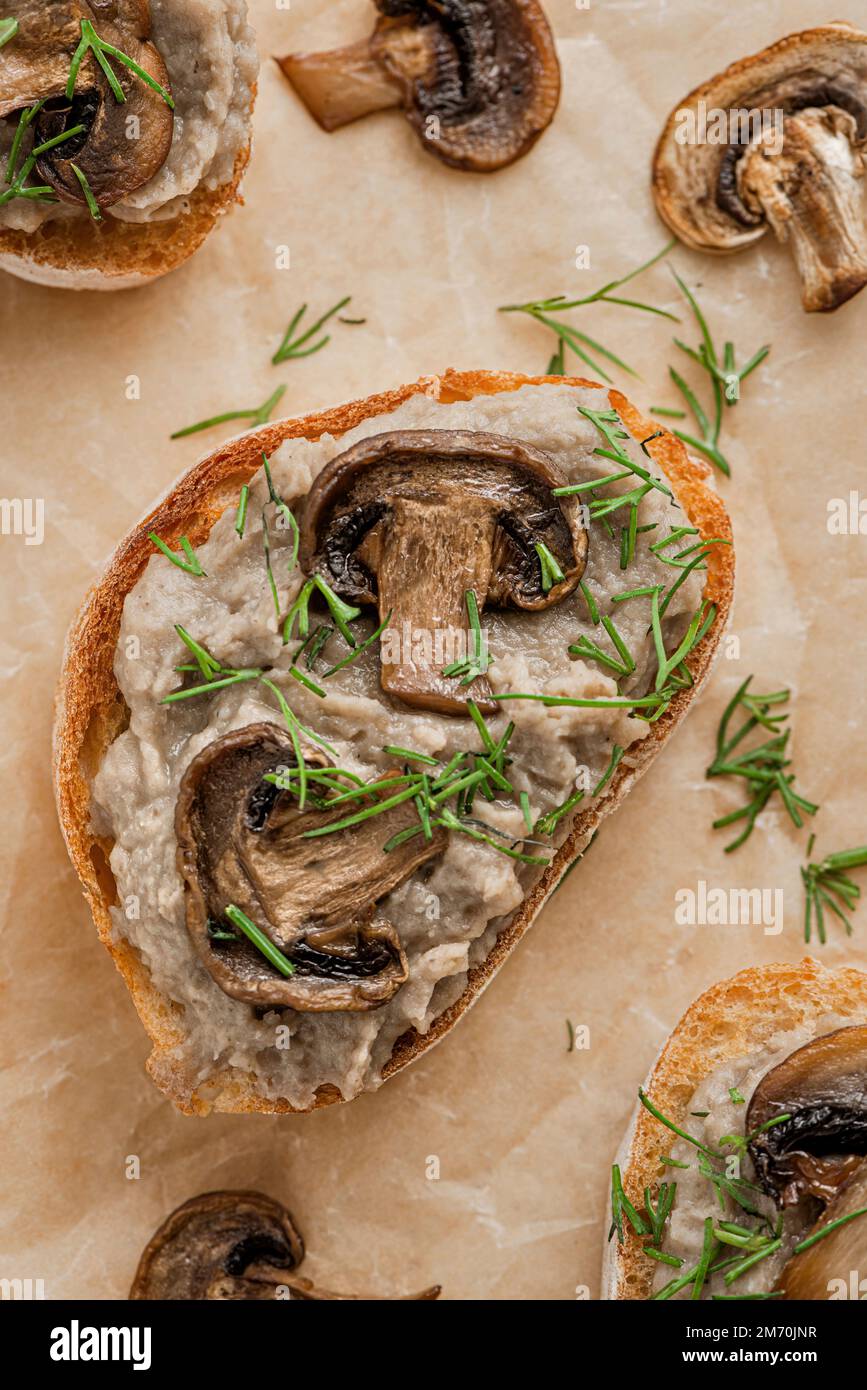 Sandwiches mit Pilzpastete und Pilzen auf Kraftpapier. Stockfoto