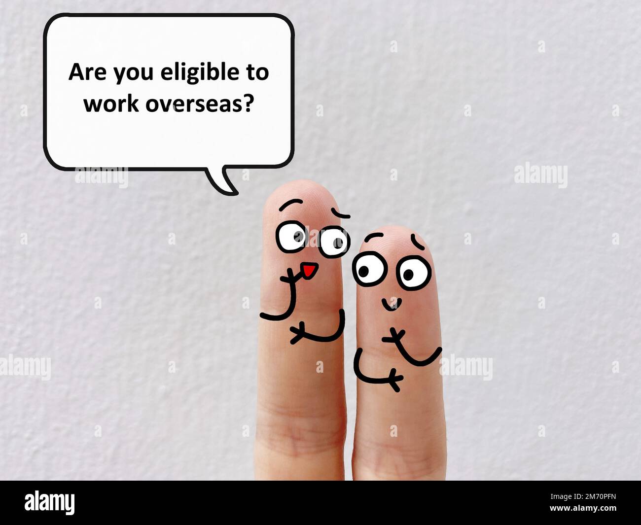 Zwei Finger sind als zwei Personen dekoriert. Einer fragt einen anderen, ob er im Ausland arbeiten kann. Stockfoto