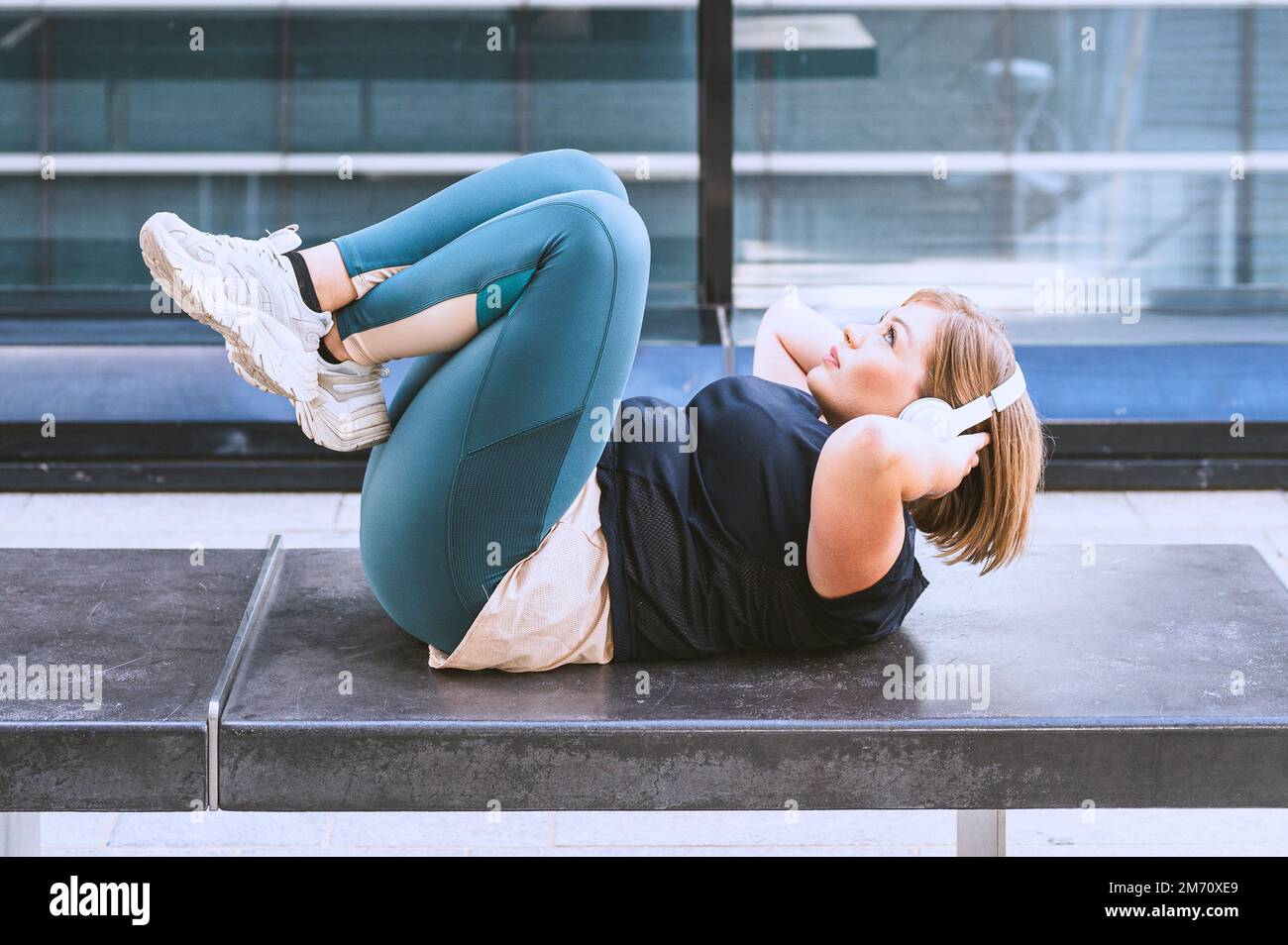 Kurvige junge Frau in Sportbekleidung Workout, plus Größe Mädchen Training in der Stadt, gesunder Lebensstil und Körper positives Konzept Stockfoto